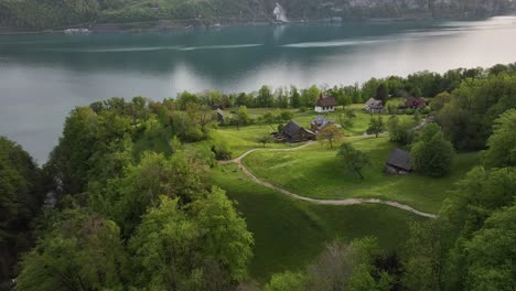 Vista-Aérea-De-Una-Meseta-Plana-Con-Casas-Con-Vistas-Al-Lago-Walensee,-Suiza,-Que-Incorpora-Una-Serena-Mezcla-De-Tranquilidad-Residencial-Y-Una-Impresionante-Belleza-Natural.