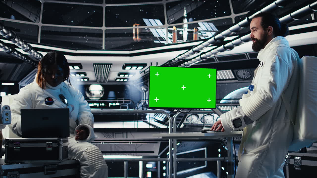 Astronauts in advanced technology spacecraft using green screen monitor