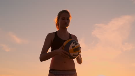 young girl jump serve volleyball on the beach slow motion