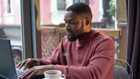 man working with the laptop in the restaurant