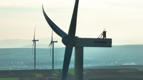 Wind-turbines-turning-on-a-sunny-day-with-distant-mountains-in-the-background