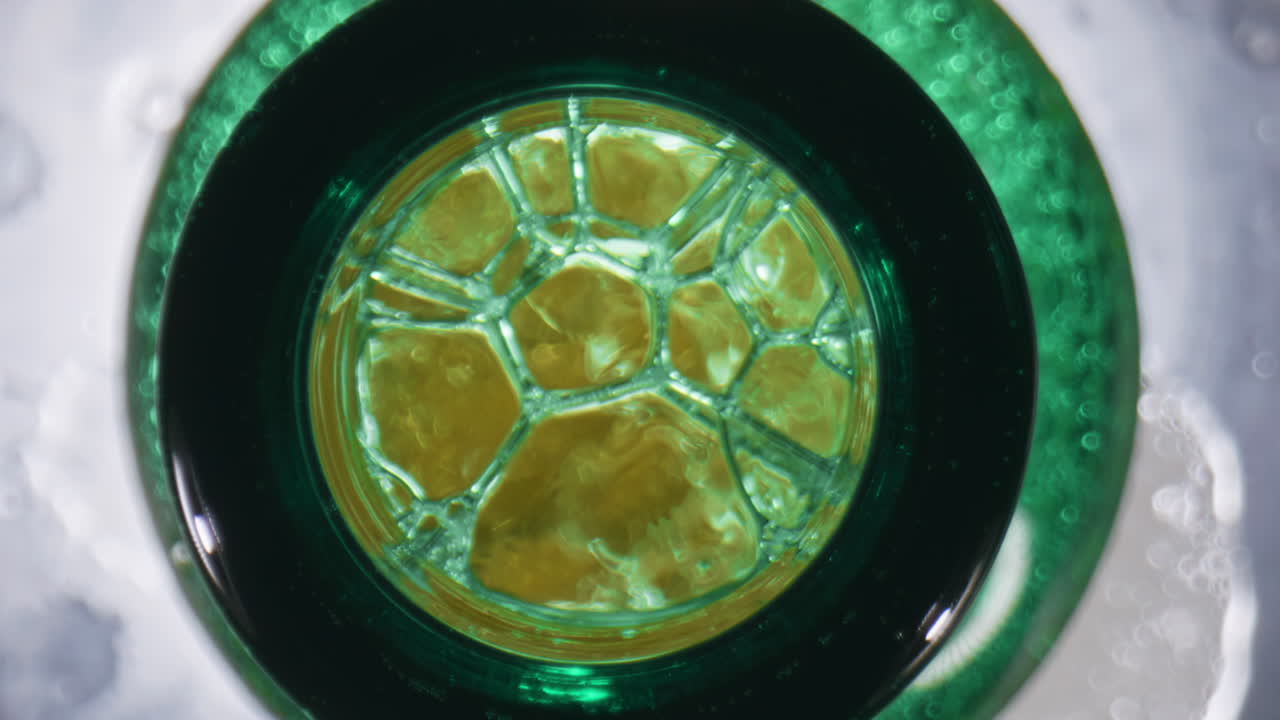 frasco de espuma de cerveza con burbujas de primer plano. frasco recién abierto de licor de lúpulo con espuma