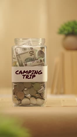 vertical video of person saving money for camping trip