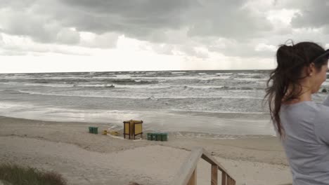 mujer joven está filmando la playa y el mar ondulado