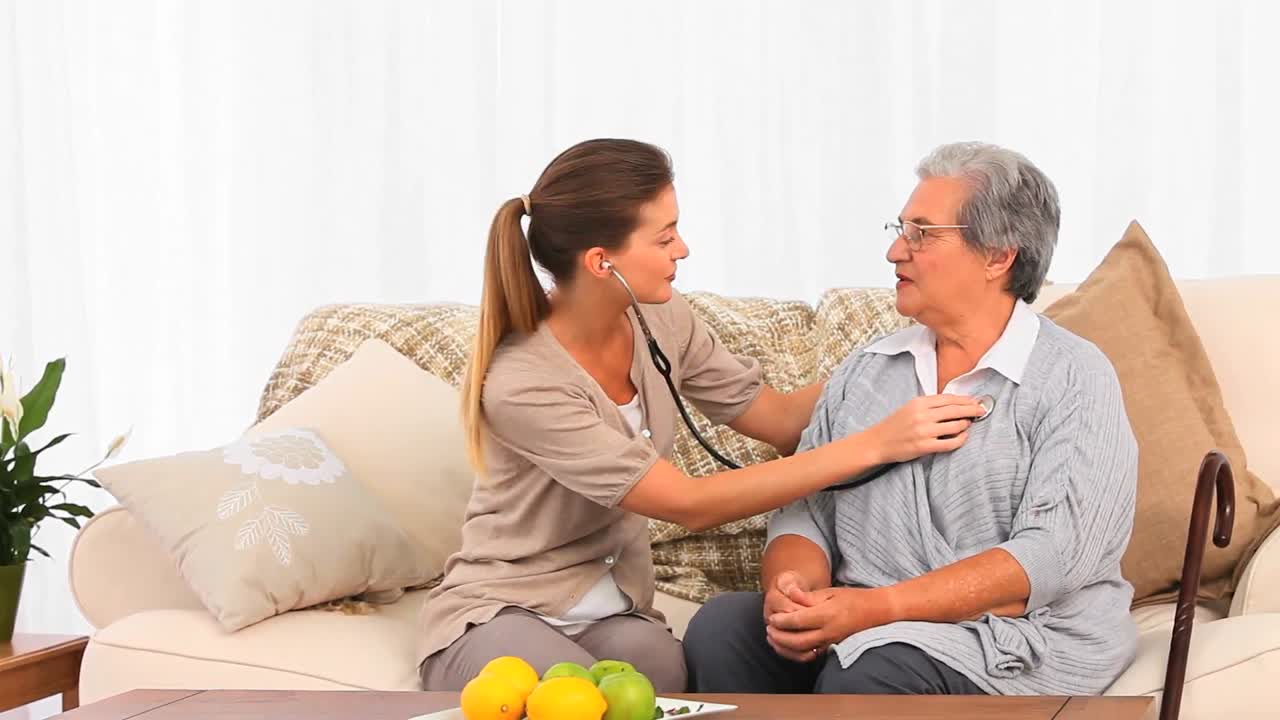 사랑스러운 간호사가 그녀의 고령 환자의 심장 박동을 취하고 있습니다.