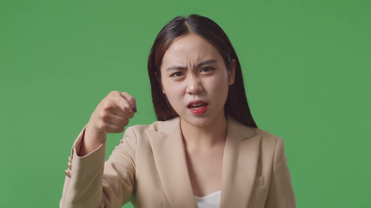 화가 난 아시아 사업가 여성이 스튜디오에서 녹색 스크린에 서서 꾸는 장면