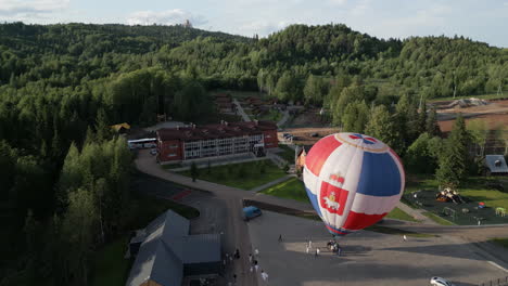 hot air balloon over a rural resort in the forest