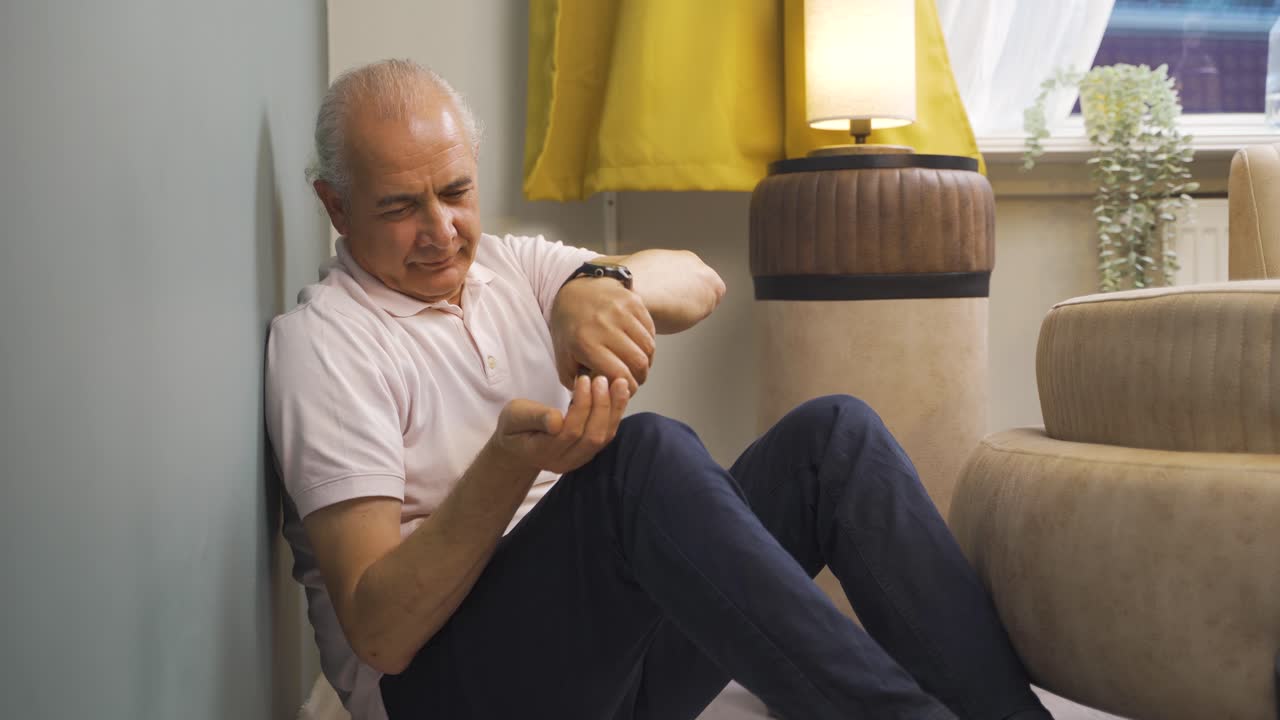 un anciano suicida apoyado en la pared.