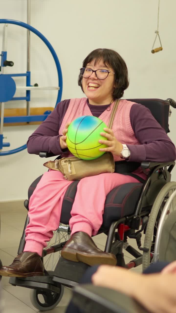 Woman in Wheelchair Throws Ball During Rehabilitation Therapy
