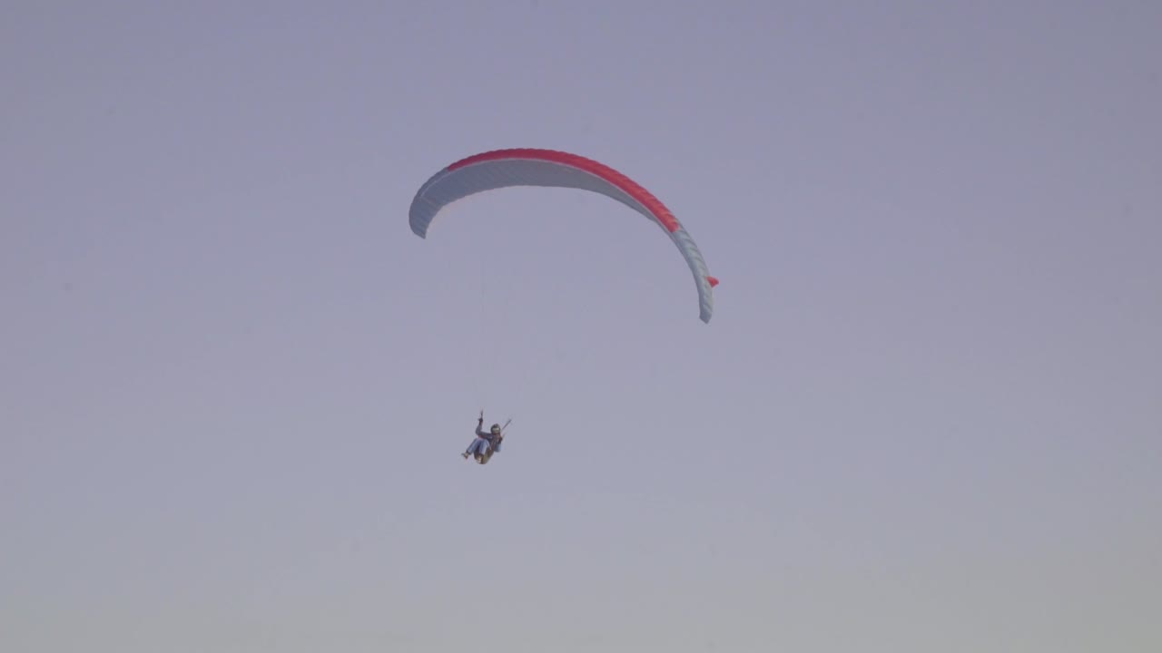 A Paraglider Lands On A Snowy Field In Latvia