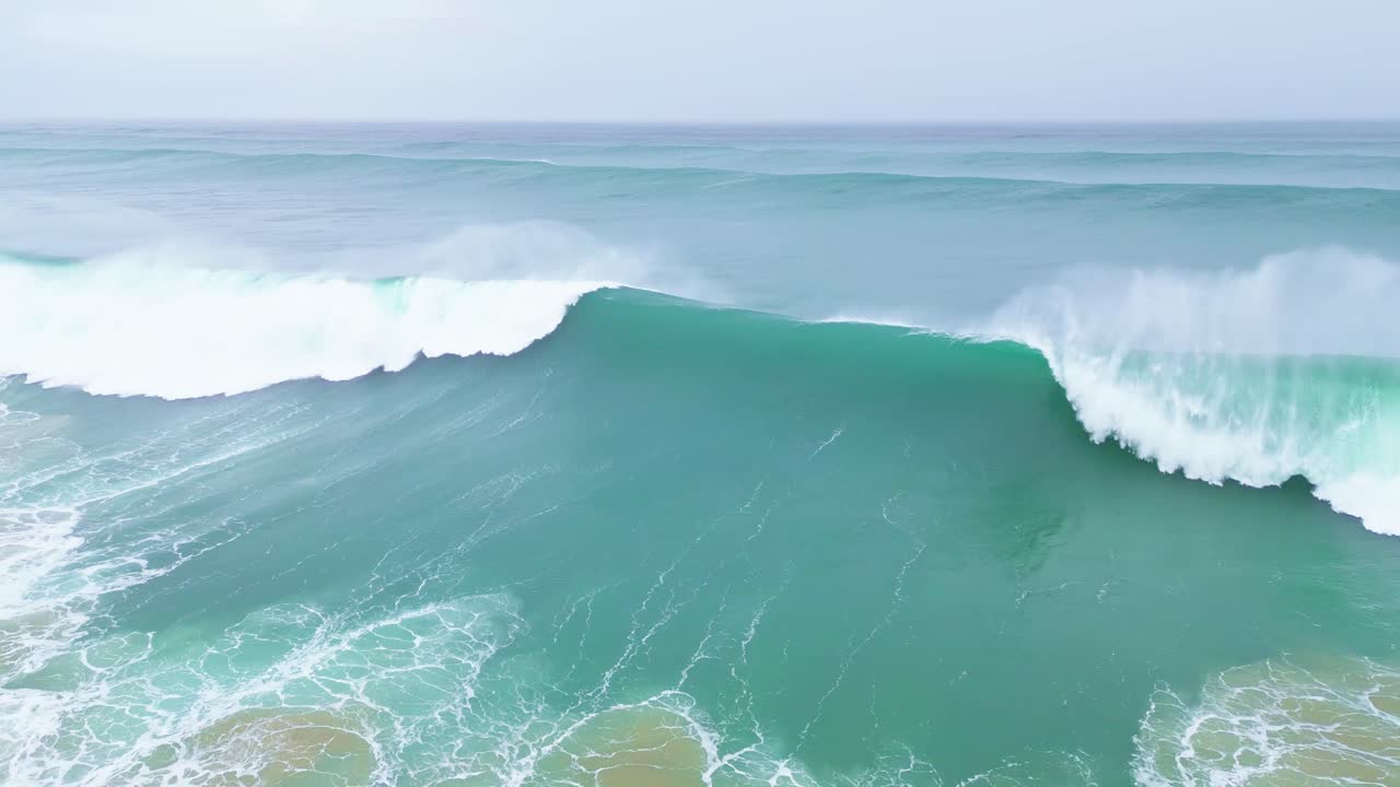Powerful ocean waves crashing against the shore, a serene moment captured in Aljezur, Portugal