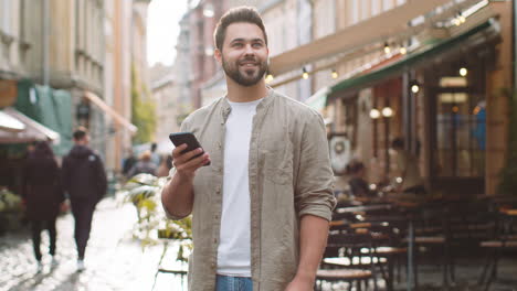 Tourist-traveler-young-man-guy-using-looking-smartphone-search-a-way-on-map-in-mobile-navigator-app
