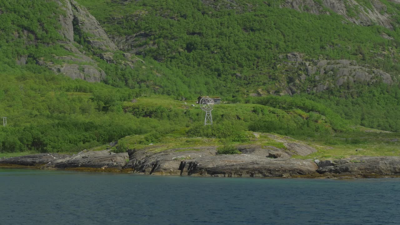 Remote Cabin on Rocky Coastline with Mountain View