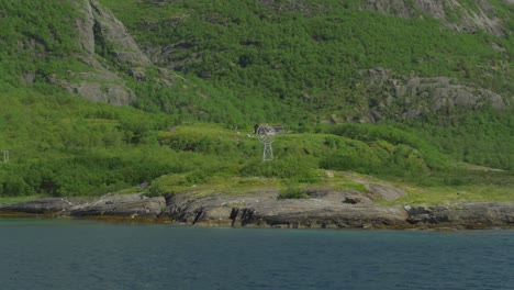 remote cabin on rocky coastline with mountain view