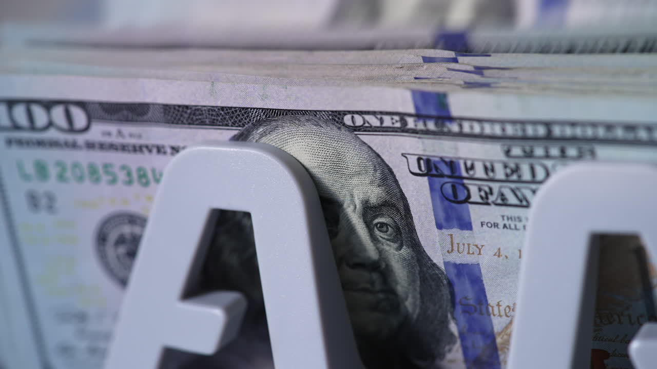 Benjamin Franklin portrait on the dollar bills. Cash counting machine counts American currency bills. Close up.