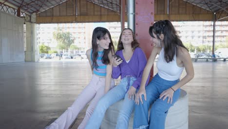 three friends laughing and using a phone