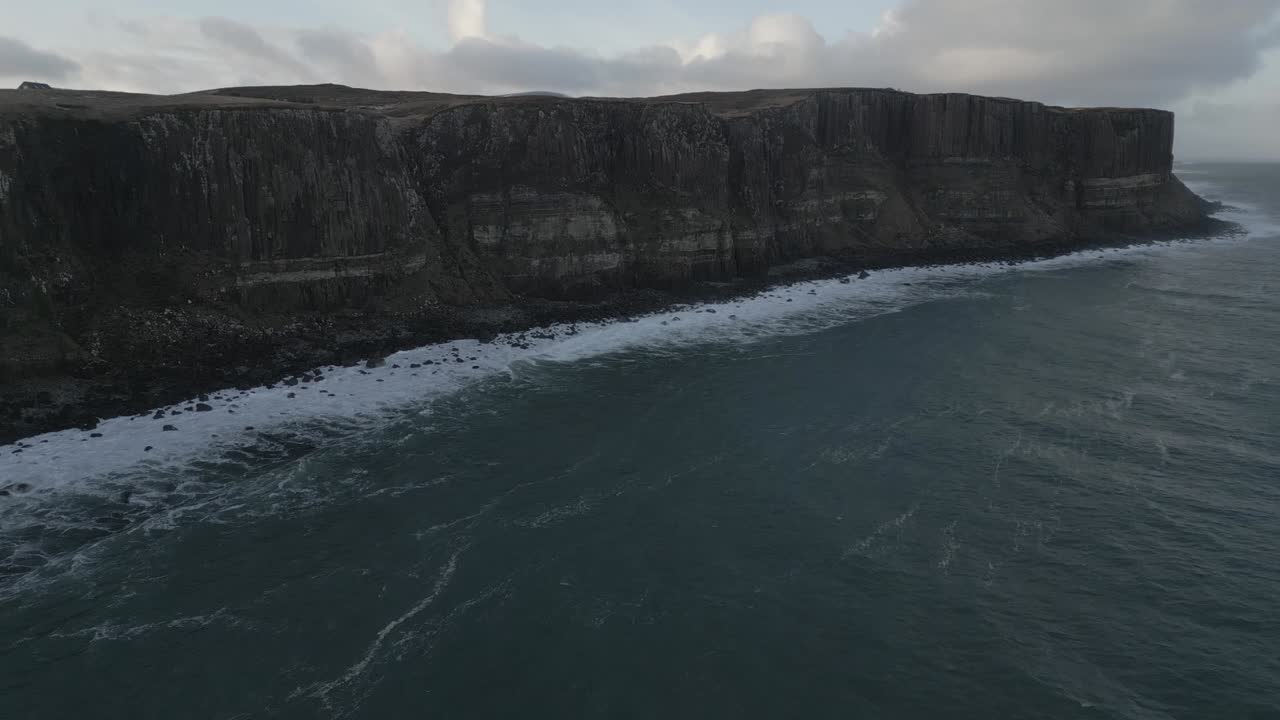 Kilt rock, scotland with dramatic cliffs and waves crashing, overcast sky, aerial view
