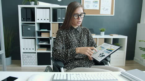 businesswoman in wheelchair reviewing documents