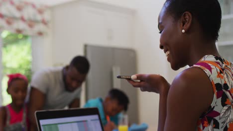 Afroamerikanische-Frau-Spricht-Auf-Dem-Smartphone,-Während-Sie-Von-Zu-Hause-Aus-Arbeitet