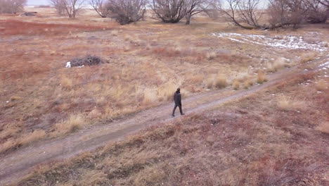 athletic man walking along a path in the winter landscape