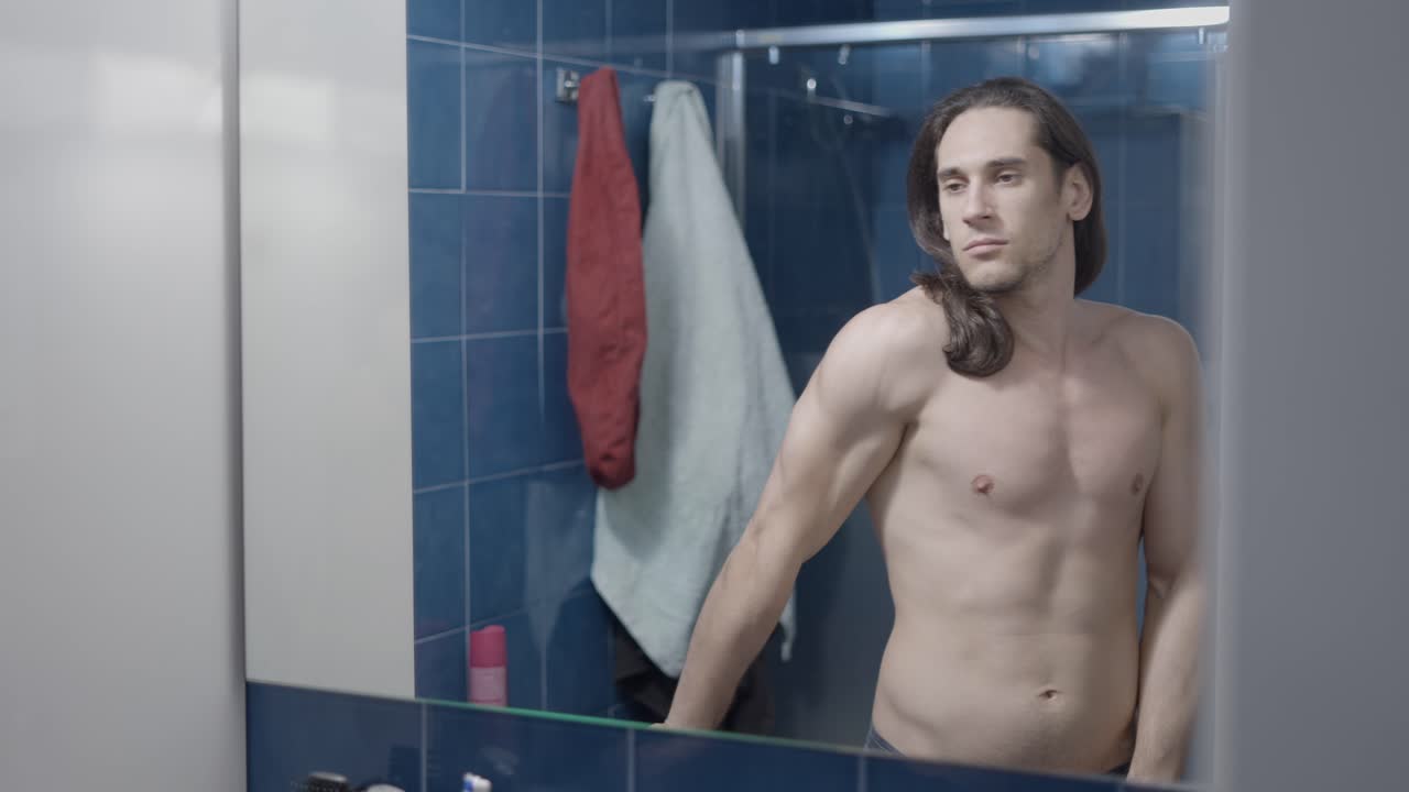 Man Checking Himself in Bathroom Mirror