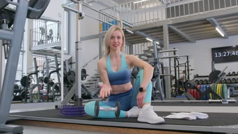 Portrait of a Young Positive Blonde Woman in a Large Modern Gym Holding a Kettlebell Portrait of a Young Positive Blonde Woman in a Large Modern Gym Holding a Kettlebell Healthy Lifestyle and Exercise Concept
