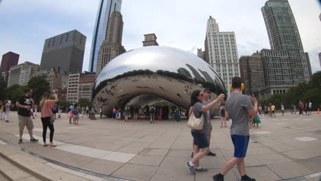 editorial, timelapse view of cloud gate, the bean, chicago, illinois, usa, public sculpture at millenium park, grant park in the loop area, downtown. urban architecture, skyscrapers and tourists.