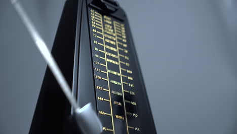 close-up shot of a vintage metronome that beats rhythm on grey background