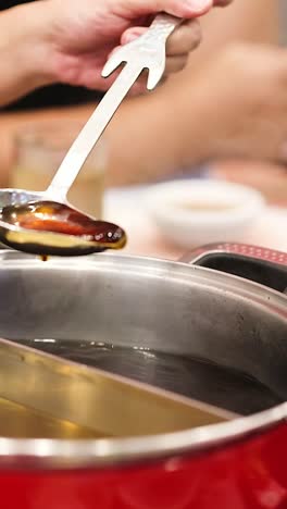 cooking and serving hotpot soup at a table