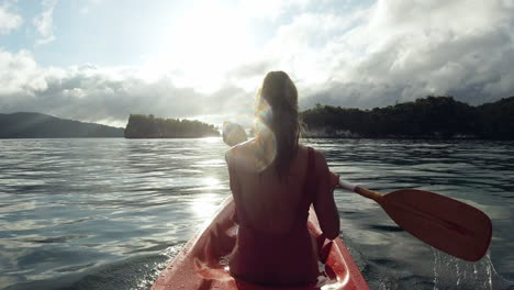 woman kayaking in tropical islands at sunrise