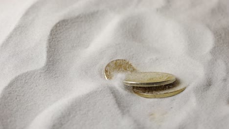 gold coins in sand