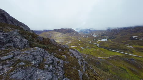 drone cinematográfico fpv volando sobre afloramientos rocosos en las tierras altas ecuatorianas para revelar un paisaje escarpado de picos de montañas, valles y lagos