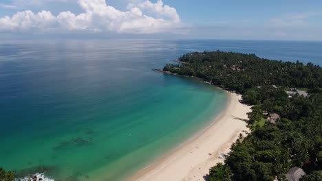 aerial shot of surin beach on phuket in thailand, flying a part of a circle in beautiful weather