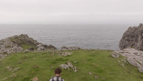 man hiking on coastal cliff