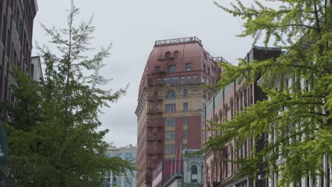 icónico edificio de dominio en la azotea roja rodeado de edificios y árboles en el centro de vancouver, columbia británica, canadá