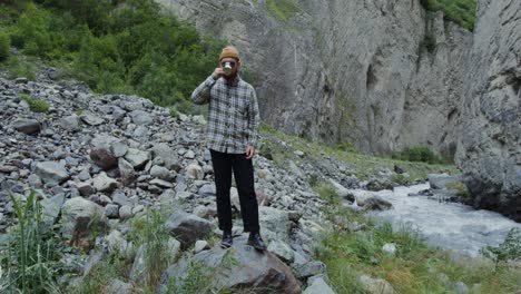 hombre bebiendo café en un cañón de montaña