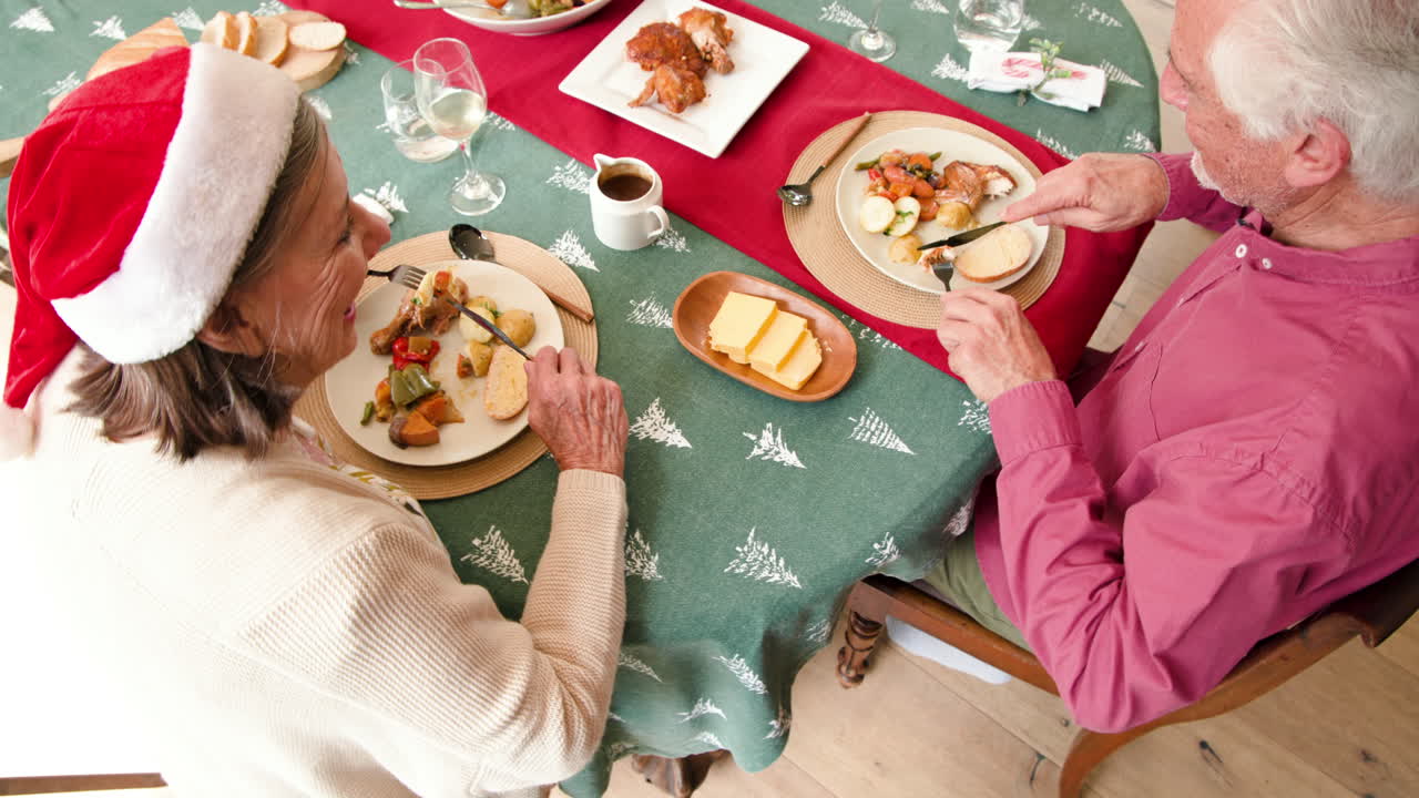 Senior couple enjoying festive Christmas dinner at home, sharing holiday joy