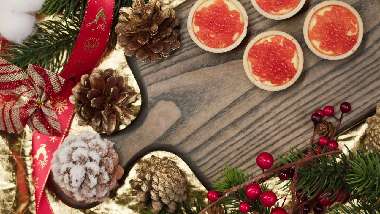 Hand Placing Red Caviar Bowl on Festive Christmas Table