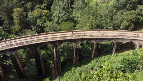 Aerial-Drone-View-of-Tourists-Walking-on-Famous-Nine-Arch-Bridge-in-Sri-Lanka