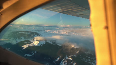 flying in a small airplane above snow capped peaks of rocky mountain near aspen colorado usa, scenic maroon bells flight, plane passenger pov