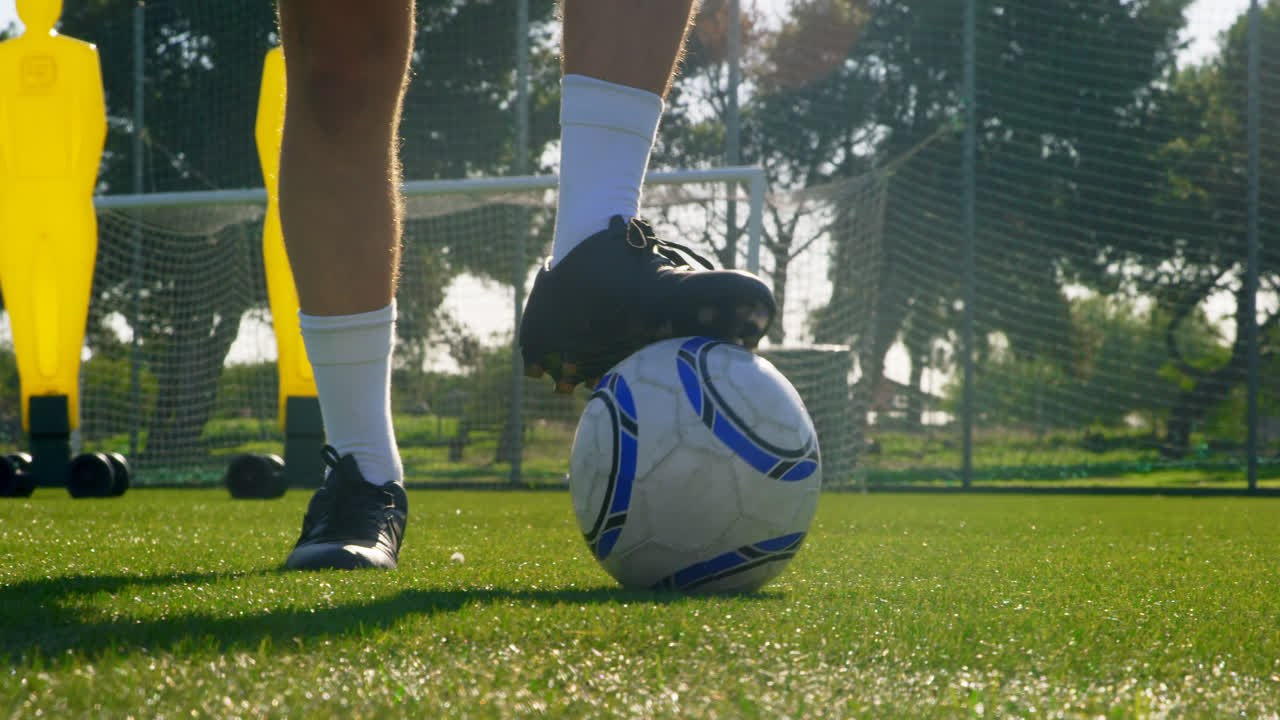 Futbolista pateando el balón hacia la portería 4k