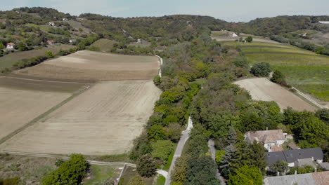 Luftaufnahme-Von-Ackerland-Mit-Feldern-Und-Häusern-In-Einem-Tal-Mit-Bäumen-Und-Dächern