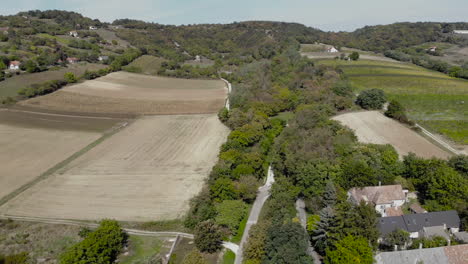 aerial view of farmland with fields and houses in a valley with trees and rooftops