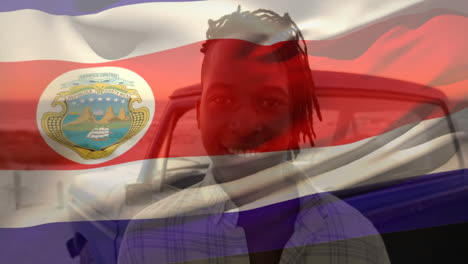 persona sonriente de pie al aire libre con animación de la bandera de costa rica en el fondo