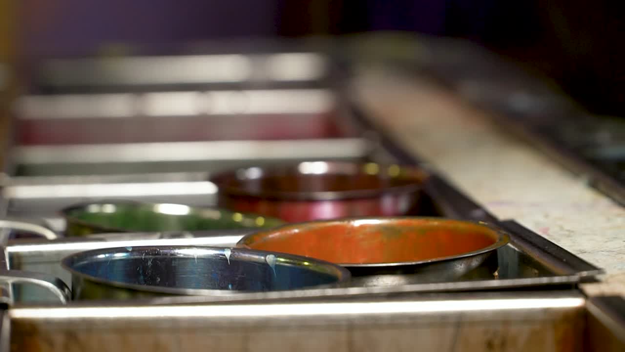 Handcrafted candles getting their color by dipping them in colorful candle wax