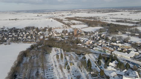 flying towards beautiful rural town surrounded by snow covered meadows