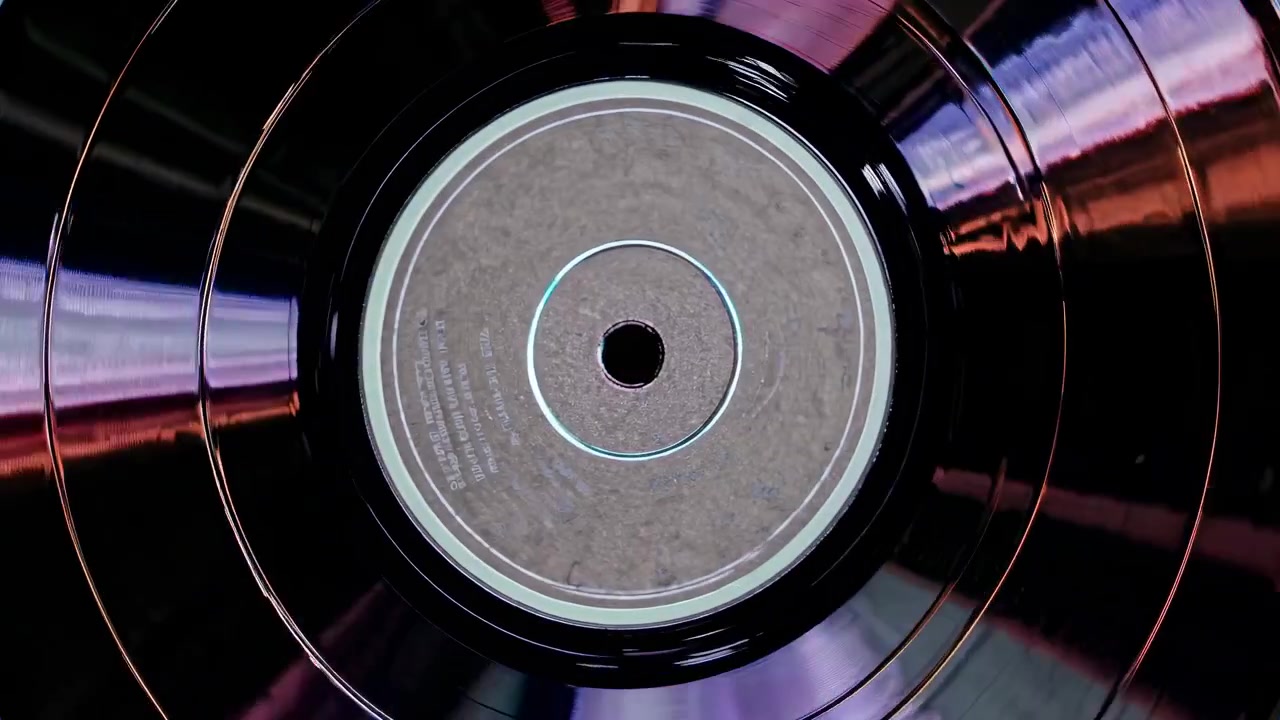 Disco in Vinile in Rotazione con Riflessi di Luce Colorati
