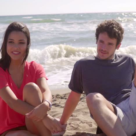 Group-Of-Young-People-Sitting-On-The-Sandy-Beach-