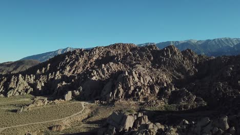 alabama hills, slope of sierra nevada, california usa. cinematic drone aerial view on rock formations under summer sun and clear sky