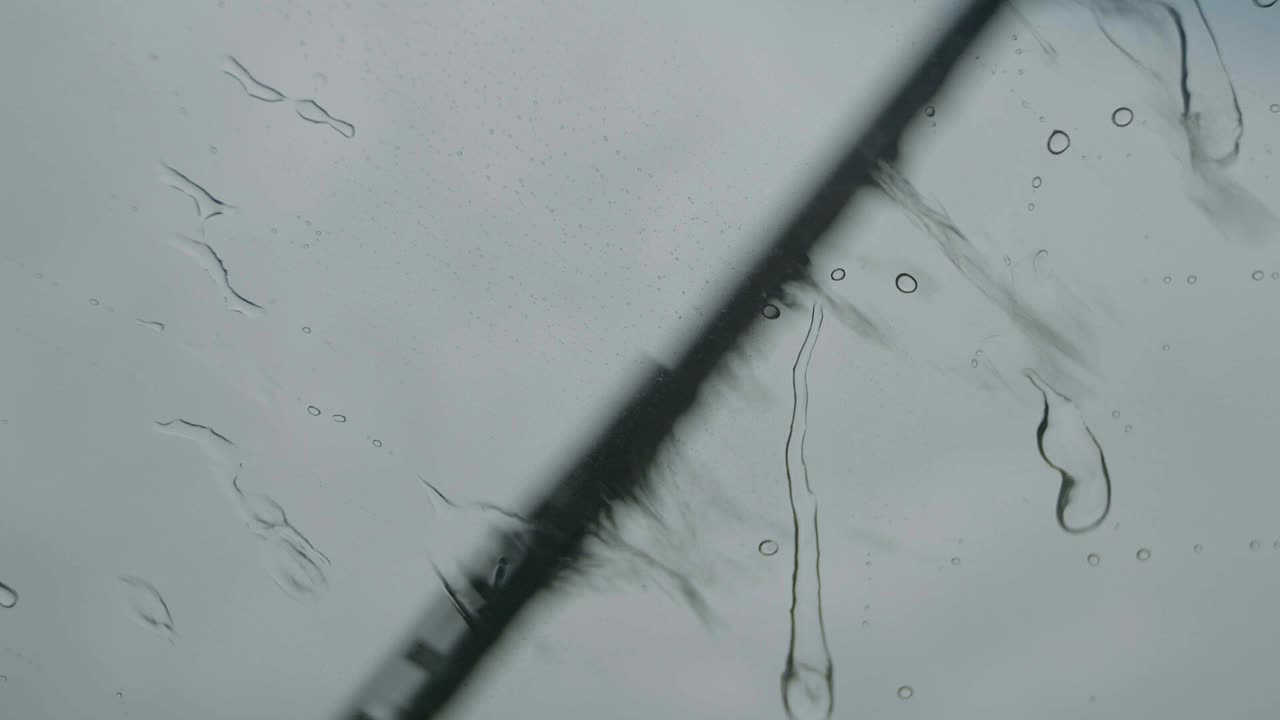 비오는 날 슬로우 모션에 자동차 앞유리 와이퍼가 닫힙니다.